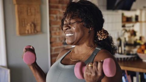 Woman at home using weights