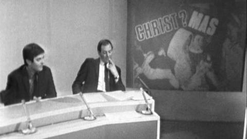 Tony Blackburn and David Coleman sit at a desk with microphone. A poster with 'Christ?Mas' is on the right of the image