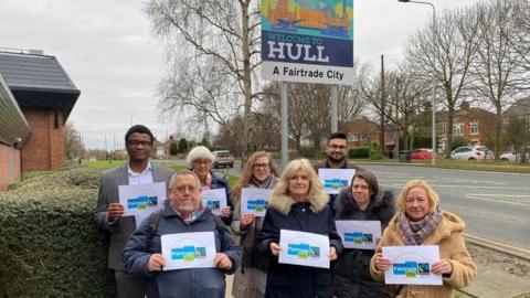 Stood in front of the new Fairtrade sign at the Bilton boundary from L-R are Ejimchi Peter-Dumbili, Peter and Chris Church, Lauren Murtagh, Julia Conner, Gurmok Sanghera, Ruth Cowlam and Sharon Clay.