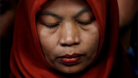 FILE PHOTO: Baiq Nuril Maknun, a teacher on the island of Lombok who was jailed after she tried to report sexual harassment, reacts during a press conference with Indonesia"s Law and Human Rights Minister Yasonna Laoly in Jakarta, Indonesia, July 8, 2019.