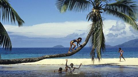 Beach on Seychelles with children playing