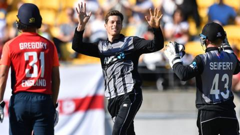 Mitchell Santner (C) celebrates taking the wicket of England's Chris Jordan during the Twenty20 cricket match between New Zealand and England at Westpac Stadium