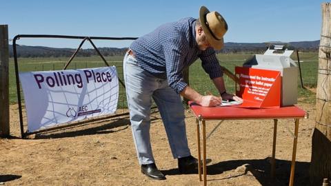 Man voting on a small table outside on a farm