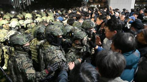 Soldiers try to enter the National Assembly building in Seoul on December 4 2024, after South Korea President Yoon Suk Yeol declared martial law.