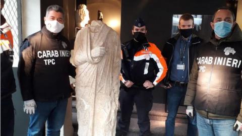 Carabinieri officers pose with the recovered statue