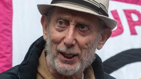 Author Michael Rosen addresses the demonstration as hundreds of people gather outside the High Court to protest against the Rwanda deportation proposal on September 5, 2022 in London