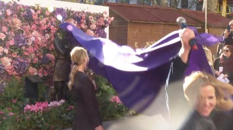 Actress Sally Phillips pulling purple rug and unveiling Bridget Jones statue