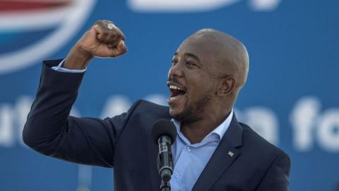 Mmusi Maimane makes a gesture with his fist