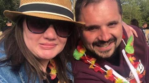 Ashleigh Crowley and David Wilson smiling wearing flower necklaces