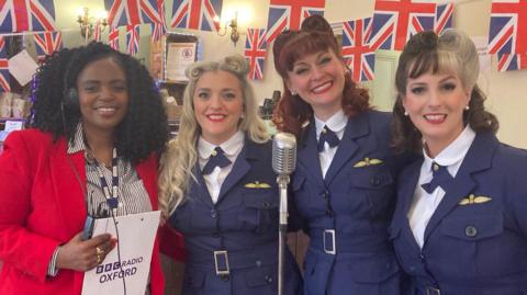 BBC Radio Oxford's Bridgette Tetteh standing with three women with 1940s hairstyles dressed in 1940s RAF uniforms