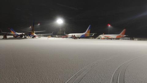 Planes sitting on a snow-covered runway at Bristol Airport