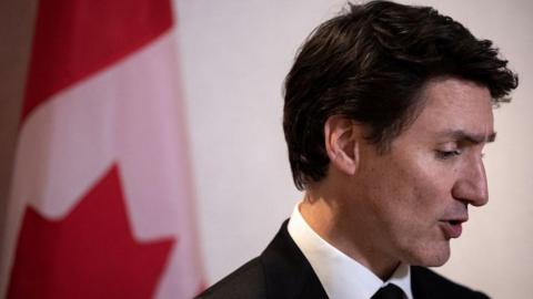 Justin Trudeau in profile against Canadian flag backdrop