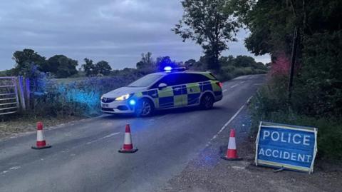 Police car and accident sign on a rural country road