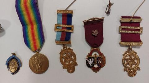 A series of five medals against a plain white background.