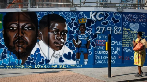 Mural of Kevin Clarke at various ages against a blue background