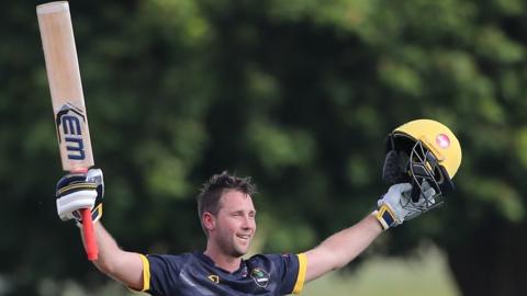 Chris Cooke of Glamorgan raises his bat after reaching his century against Middlesex