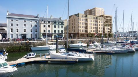 An illustration of the development from across the harbour. It shows the a series of light-coloured buildings next to other lower buildings on North Quay. There are boats moored in the harbour in the front.