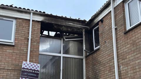 Damage from the fire visible to the roof and windows after the fire in the corner of the building.