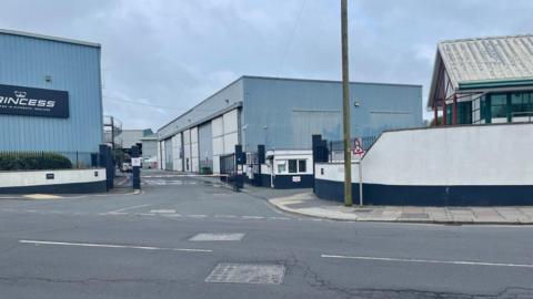 A building branded Princess can be seen to the left, with other warehouse type buildngs to the right with a road in the foreground. 