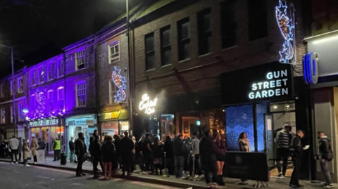 Queues and smokers outside the Cocktail Club and Gun Street Garden in Gun Street on a Friday night in Reading town centre