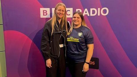 Hannah Hampton is standing next to Kaitlyn Clark in front of a purple BBC Radio WM backdrop 