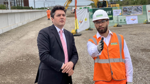 Rail minister Huw Merriman with a construction worker during his visit to the site where the station is being built
