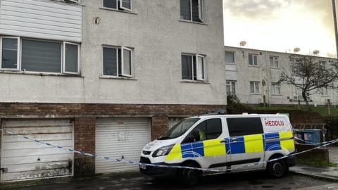 Flat on the Wildmill estate with police van and tape