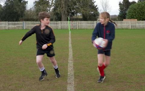 Two rugby playing Press Packers pass the ball between each other. 