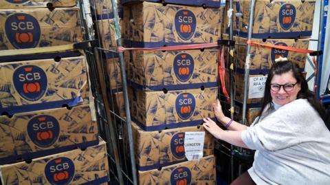 Tesco Kirkwall's community champion with boxes of bananas