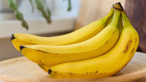 A bunch of bananas on a wooden plate