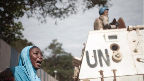 A woman reacts next to UN soldiers as inhabitants of the mainly Muslim PK5 neighbourhood demonstrate in front of the headquarters of MINUSCA, the UN peacekeeping mission in the Central Africa Republic, in Bangui, on April 11, 2018.