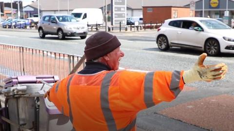 Street cleaner waving