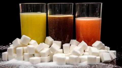Fizzy drinks surrounded by sugar cubes
