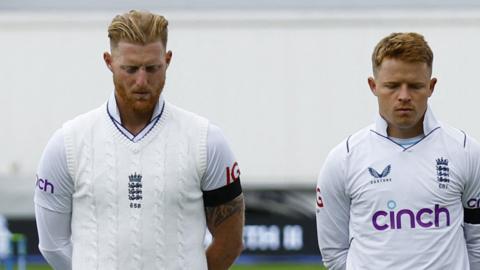 Ben Stokes (left) and Ollie Pope looking down during England's minute of silence for Queen Elizabeth II.