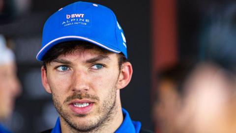 Close up of Alpine driver Pierre Gasly wearing a blue team baseball cap