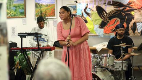 A band are on the stage at Common Ground. The singer, keyboard player and drummer are poised to play.