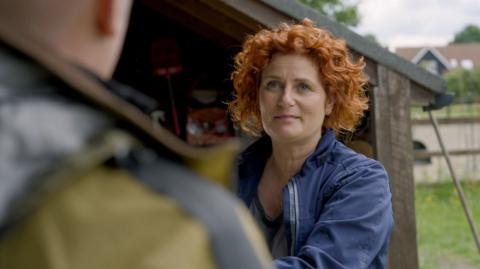 Woman with red hair and a blue jacket
