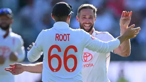 England bowler Chris Woakes embraces Joe Root to celebrate taking a wicket