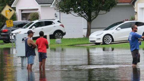  Residents stand in a street that was flooded by rains from Hurricane Milton on October 10, 2024 in Altamonte Springs, Florida