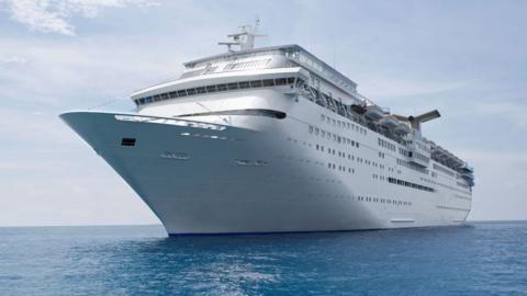 A cruise ship at sea with calm waters and clear skies