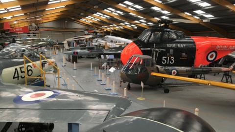 Hangar 1 at Newark Air Museum, showing various aircraft, including helicopters, separated by a central walkway