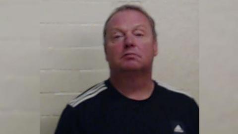 Berry has a dark Adidas top on. He has short hair.