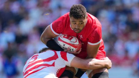 Taulupe Faletau yn cael ei daclo gan Shuhei Takeuchi