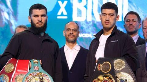 Artur Beterbiev and Dimitry Bivol pose with their belts at a news conference