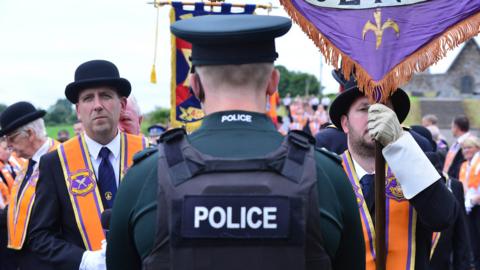 A policeman stands in front of Orangemen at Drumcree in 2022