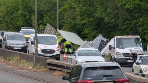 The aftermath of a collision involving a lorry on the A52, with traffic now passing the scene