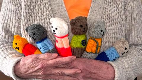 Granny H holding six hand-knitted bears