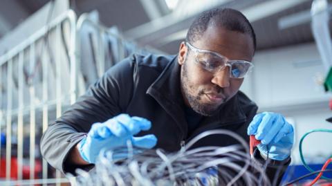 Electrical engineer assembling components in electronics factory