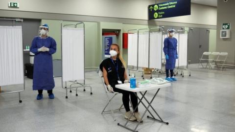 Medical staff wait to test arrivals in Greece