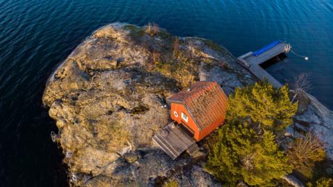 Aerial view of a cozy sauna in the middle of lonely island in Sweden.